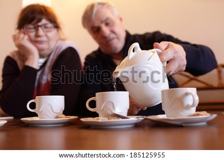 Senior man pouring tea in a restaurant