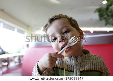 Child eating noodles at the asian restaurant