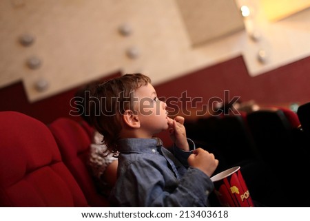 The child in the cinema with popcorn