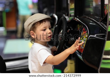 Child playing arcade game machine at an amusement park