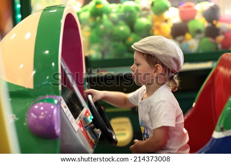 Boy playing arcade game machine at an amusement park