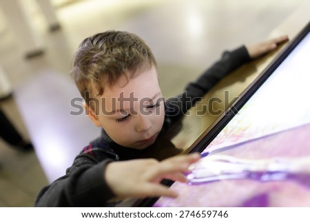 Kid using touch screen in the museum