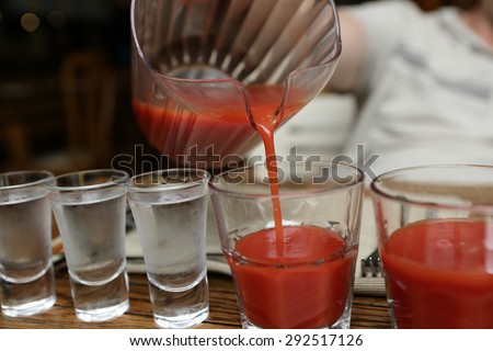 Person pouring tomato juice in the pub