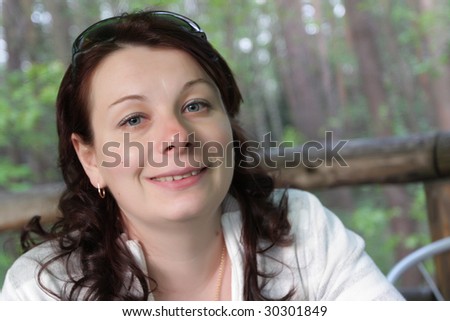 The cheerful young woman poses in summer cafe