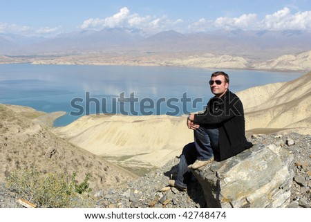 The tourist rests on Toktogul Reservoir. Toktogul Reservoir, located in the Jalal-Abad Province of Kyrgyzstan, is the largest of the reservoirs on the path of the Naryn River.