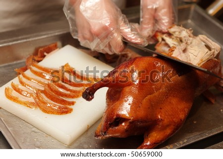 Chinese cook prepares Peking Roast Duck. Peking Duck is a famous duck dish from Beijing that has been prepared since the imperial era, and is now considered one of China\'s national foods.