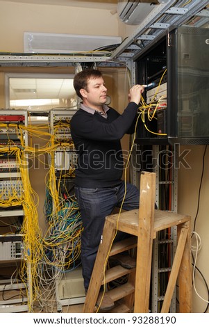 The technician working on the stepladder at the server room