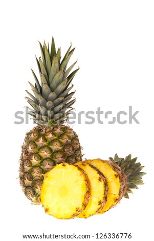 A whole pineapple and a pineapple cut into slices in front of white background