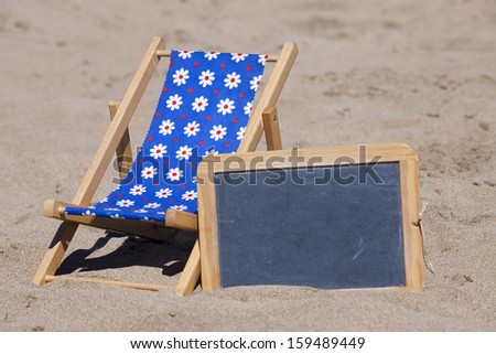Beach scene in the Summer with a Sun Chair on the Beach with Copy Space on a Slate in right part of image