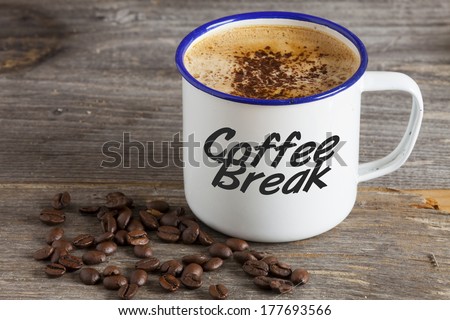 Enamel Mugs with hot Coffee and Coffee Beans on a rustic wooden board with the Word \