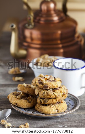 Coffee Time with homemade Walnut Chili Cookies on a Plate and a Coffee Cup and Water Kettle in the Background