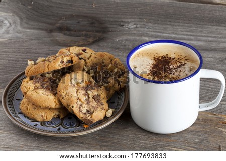 Plate of cookies and a Enamel Mugs with coffee on a rustic wooden board with Copy Space on the Coffee Cup