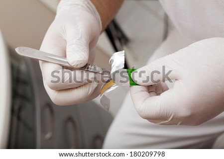 Chiropodists puts the scalpel blade from the package to a scalpel