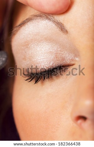 Macro shot of of the face of a pretty young woman with closed eyes at her beautician