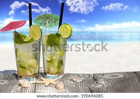 Refreshing Mojito Cocktail on Wooden Boards with Starfish and Sea Shell on the Beach with much Copy Space for additional information