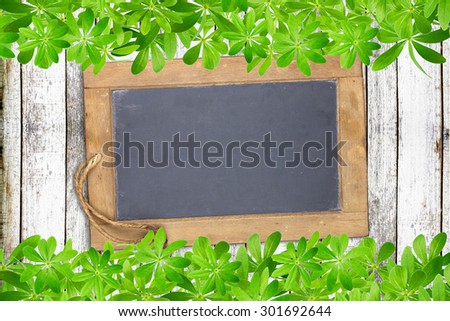 Slate board framed top and bottom with woodruff leaves on old rustic wooden planks