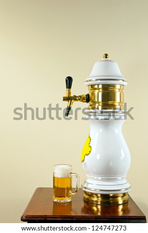 Side view of decorative beer nozzle with tap and beer pint.