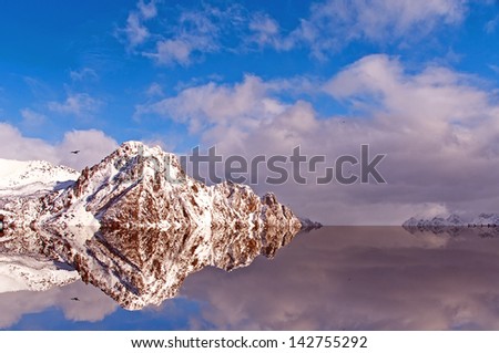 Reflections of the snowy mountains in the Arctic Circle on a sunny day and colorful winter