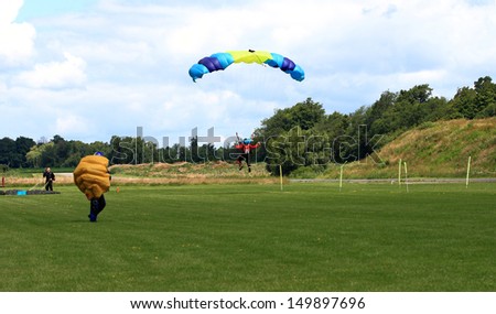 WATERDOWN, ONTARIO/CANADA - AUGUST 2013: Skydiver Lands on Earth after perform jump in formation on August 4, 2013 in Waterdown. Seen part of the group and the videographer of jump on Civic Holiday
