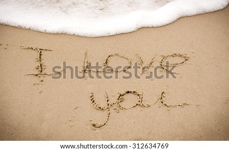 Declaration of love written by hand at the sea sand
