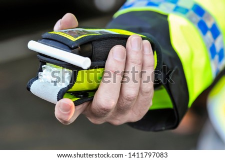 Belfast, Northern Ireland. 24 Nov 2016 - A police officer holds a roadside breathalyser alcohol breath test after taking a sample from a driver.