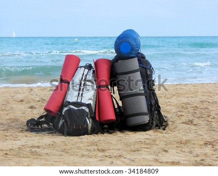 backpack and tourist equipment on a beach of Mediterranean sea, Spain, Barcelona