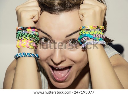 Crazy young woman with colorful rubber bracelets on her hands. Beauty and fashion.