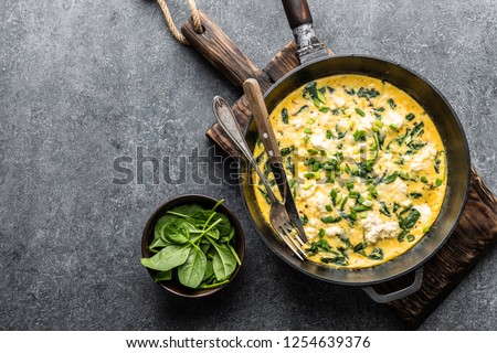omelette with spinach and cheese in a pan on the concrete background top view Stock fotó © 