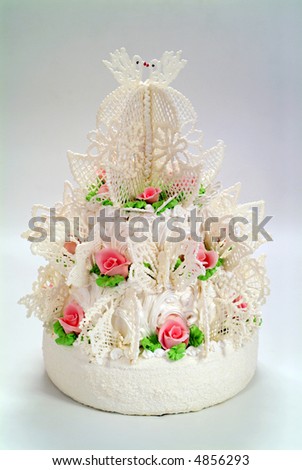 Beautiful multi-tiered wedding cake with white frosting. The cake is decorated with purple roses