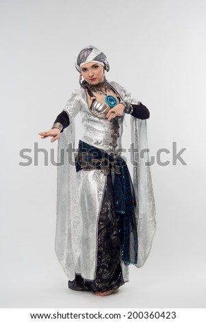full length portrait of unforgettable oriental woman showing exiting motions of dance. Isolated on white background
