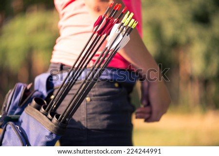 Selective focus on the bag with bows hitched to the waist of the girl standing aside