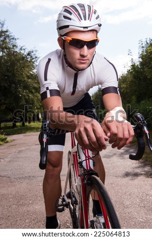 Full-length portrait of the man wearing sport uniform and sunglasses riding the great bike to us going in for his favorite activity