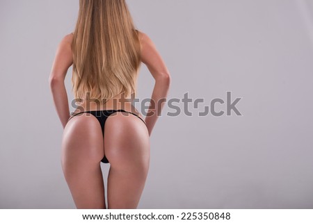 Half-length portrait of sexy beautiful blonde with great figure wearing black lingerie standing back showing the beauty of her wonderful body. Isolated on white background