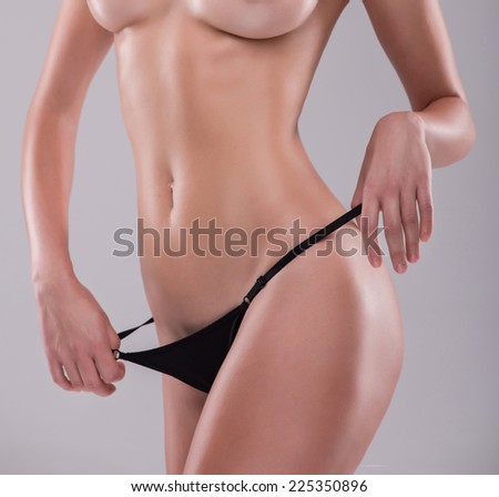 Half-length portrait of sexy beautiful blonde with great figure wearing black lingerie showing the beauty of her wonderful body. Isolated on white background