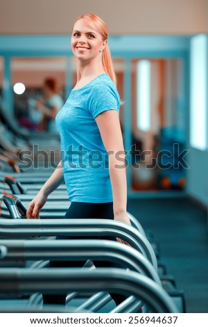 Keeping fit and young. Side view of beautiful mature woman in sports clothing having a workout on a treadmill in the gym