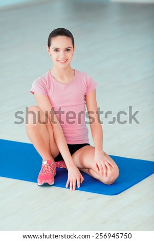 Fresh and healthy. Top view image of beautiful teenage girl in sports clothing training yoga position on the mat in health club