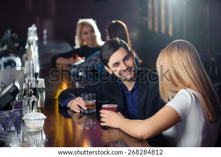 Long night. Couple joyfully interacting by the bar counter in nightclub or restaurant