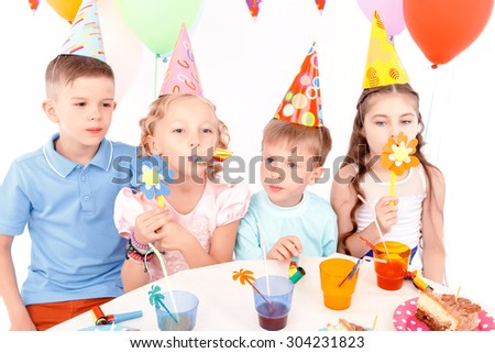 With flowers. Two little boys and pair of beautiful girls playing with toy flowers at birthday party.