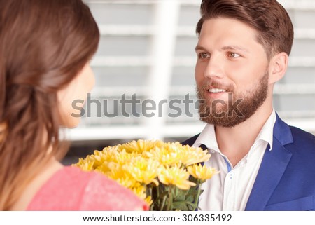 Beautifl couple. Handsome young guy giving bouquet with beautiful flowers to his pretty girlfriend.