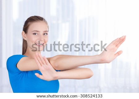 Best way to feel healthy. Upbeat nice girl holding hand lifted and doing morning exercises while feeling blissful