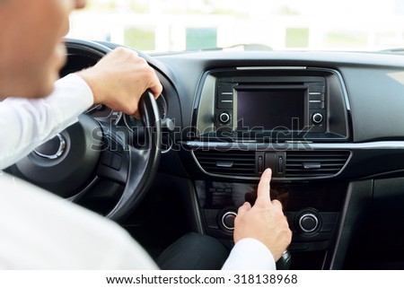 Just turn it on. Nice young businessman holding steering wheel and pressing the button while driving a car