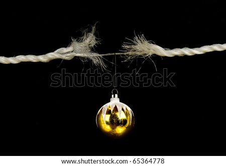Frayed rope with christmas bulb holiday stress concept isolated on black background