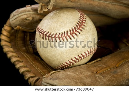 A baseball ball on a glove with black background