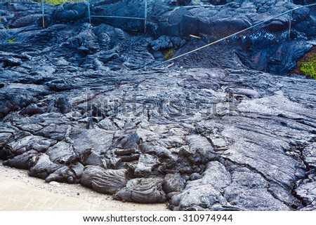 Advancing lava in the town of Pahoa melts and moves through a fence, Big Island, Hawaii
