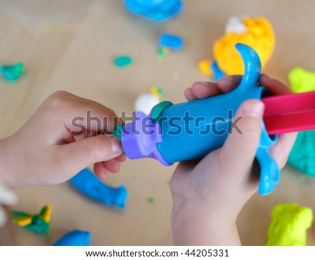Hands of child working with play dough