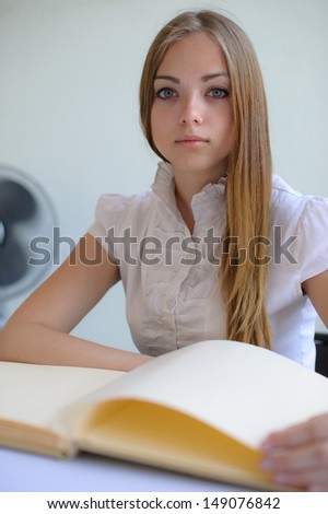 portrait of the beautiful girl with a flowing hair reading the book