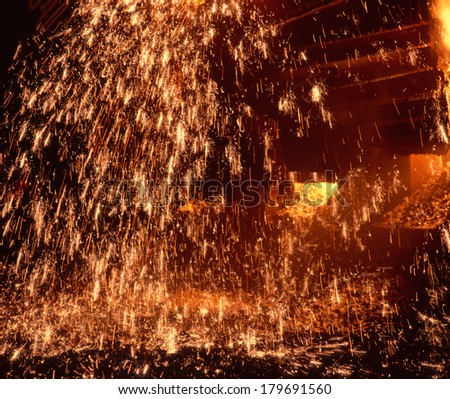 Metallurgic production, production of cast iron, metal melting. Fire sparks and molten metal splashes.