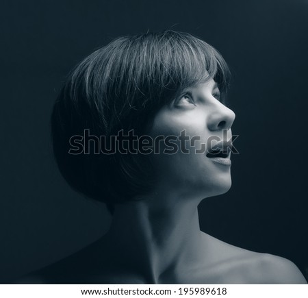 young beautiful woman looking up on a dark background, age 30 years
