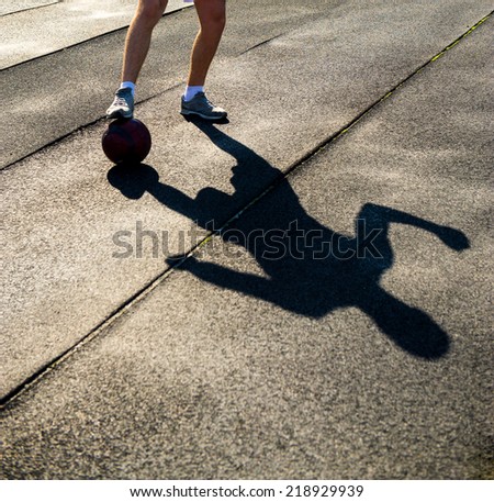 athlete with the ball and shadow on a dark background
