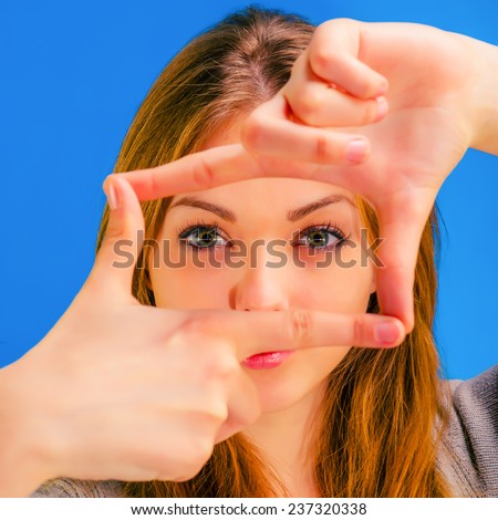 young beautiful girl looks crossed fingers frame